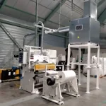 extractor industrial conectado a una máquina de laminado, optimizando la ventilación y el control de partículas en la fabricación