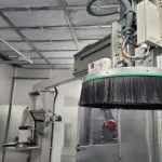 Brazo industrial con cepillo y aspiración eficiente para tareas de limpieza en entornos industriales.